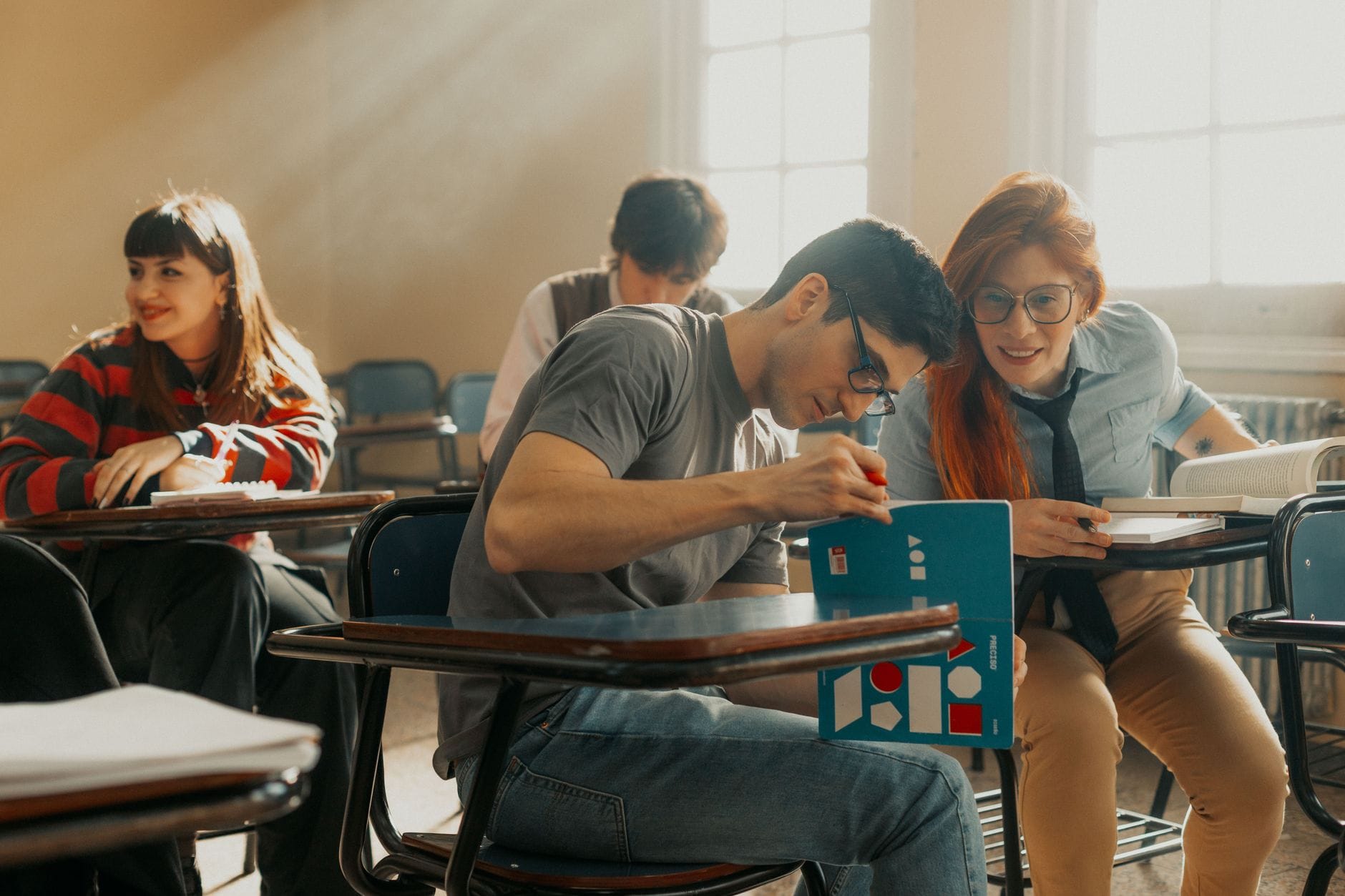 Studenci uczący się razem w jasnej sali wykładowej